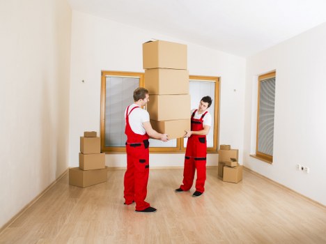 Trained removals staff using safe lifting techniques in a home move